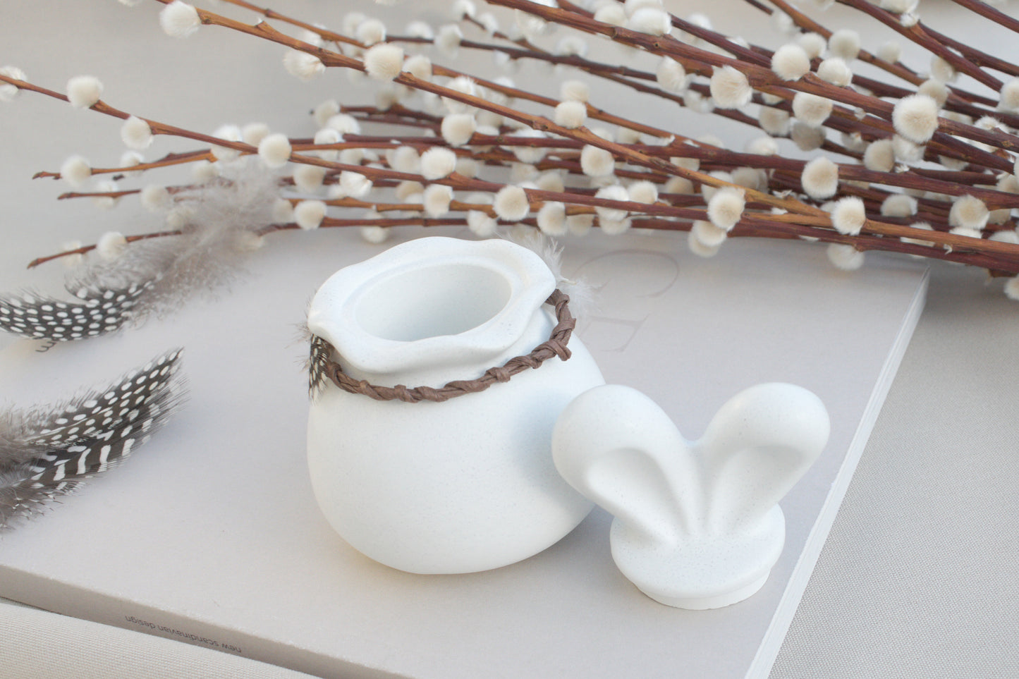 Osterdeko Skandi – Dose aus weißem Beton mit Hasenohren & Perlhuhn-Federn