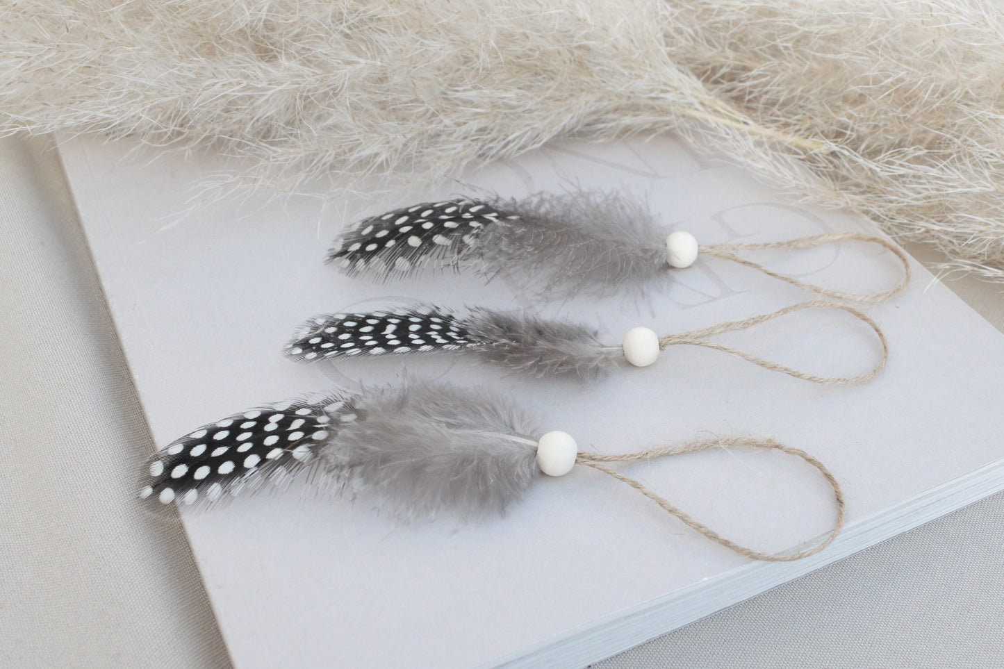 Osterdeko Anhänger Set aus gepunkteten Perlhuhn-Federn mit Naturholzperle