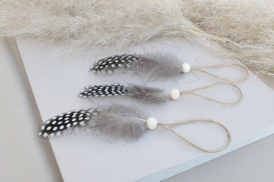 Osterdeko Anhänger Set aus gepunkteten Perlhuhn-Federn mit Naturholzperle