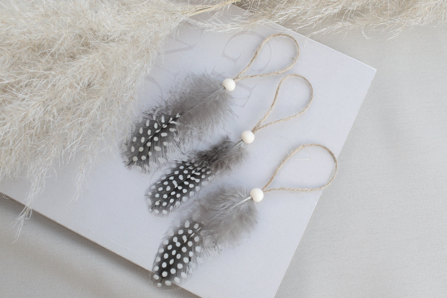 Osterdeko Anhänger Set aus gepunkteten Perlhuhn-Federn mit Naturholzperle