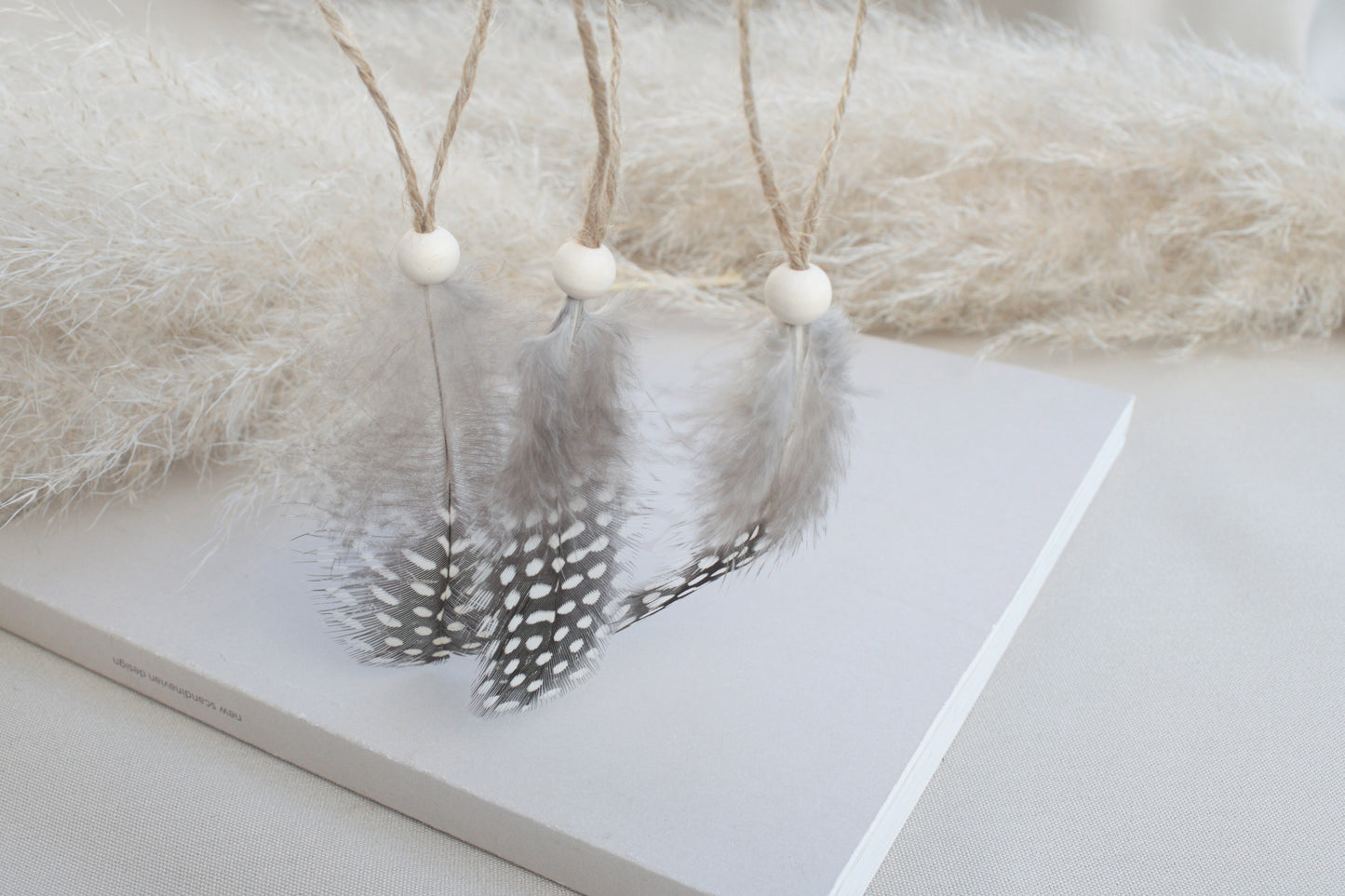 Osterdeko Anhänger Set aus gepunkteten Perlhuhn-Federn mit Naturholzperle
