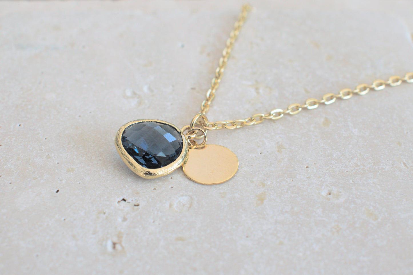 Damenkette in gold mit einem blauen Anhänger und einem minimalistischen runden Anhänger in gold