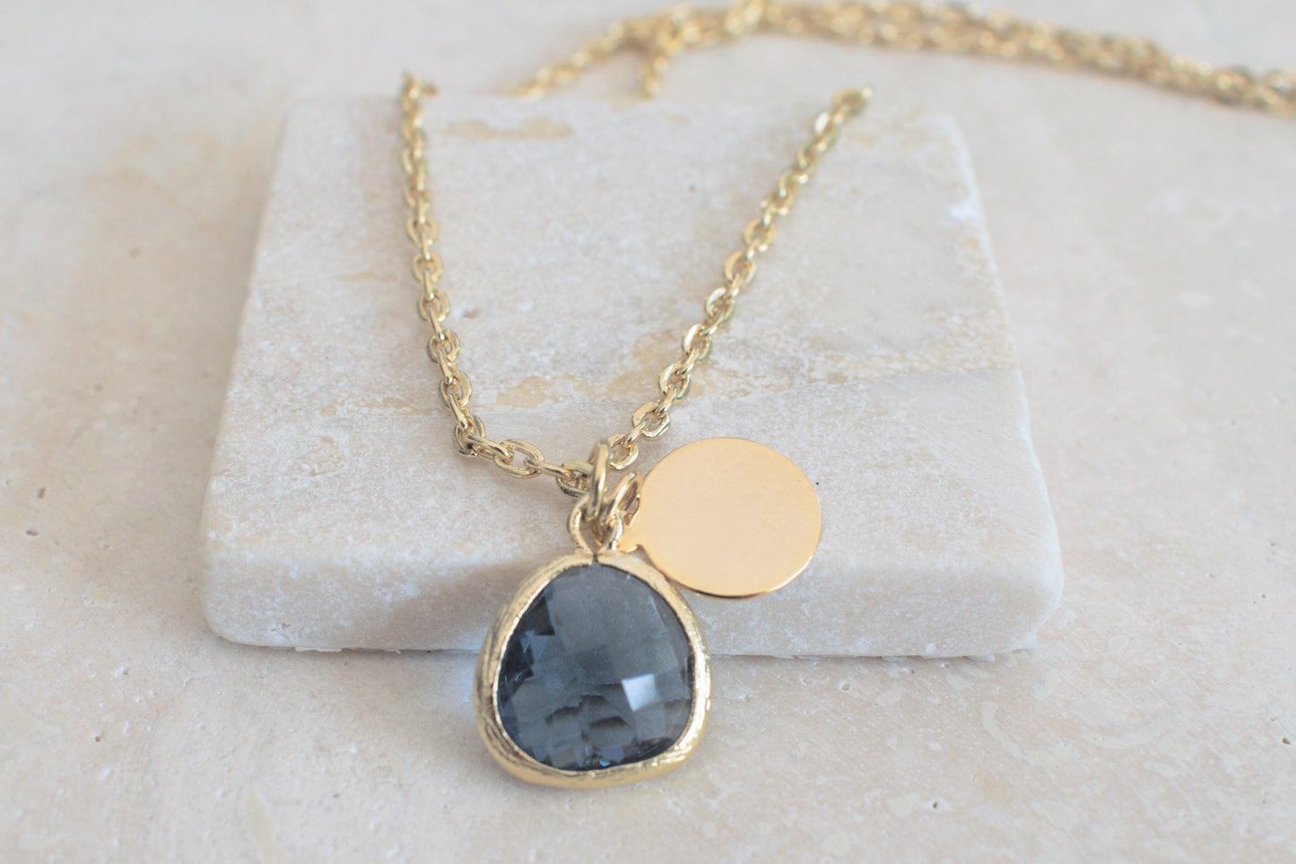 Damenkette in gold mit einem blauen Anhänger und einem minimalistischen runden Anhänger in gold