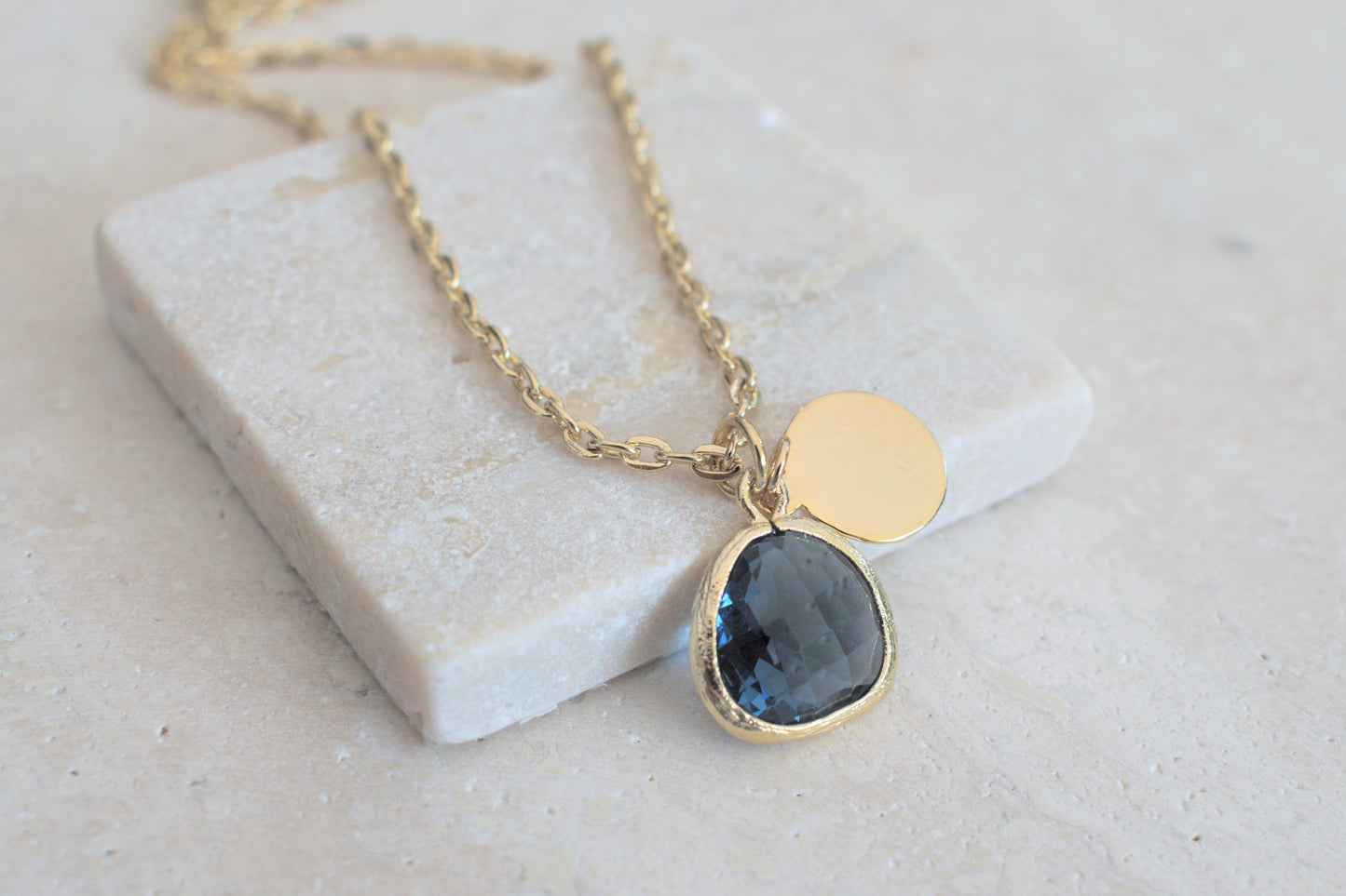 Damenkette in gold mit einem blauen Anhänger und einem minimalistischen runden Anhänger in gold