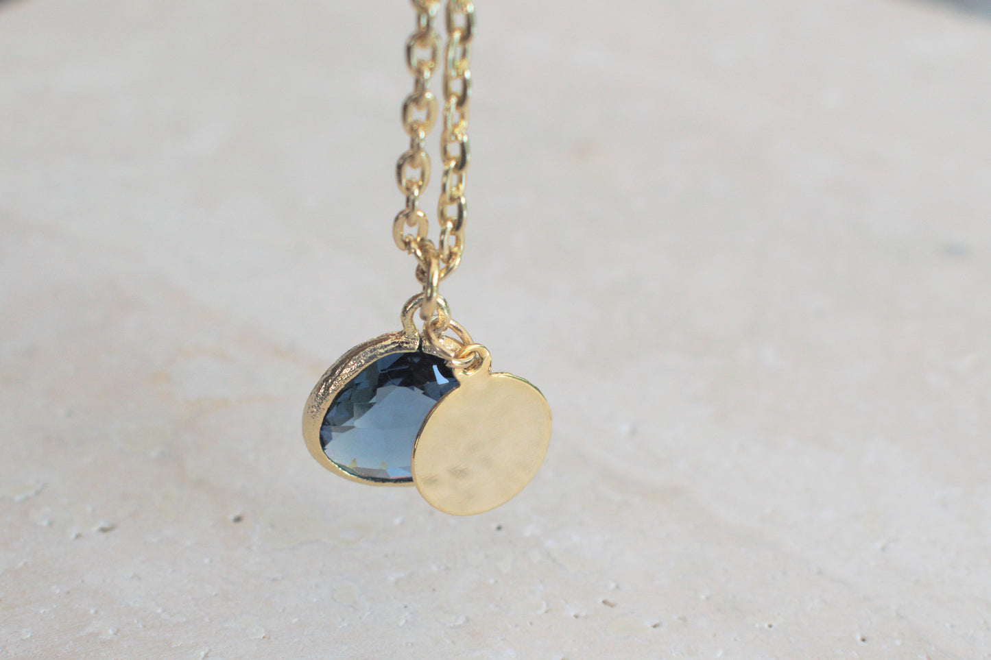 Damenkette in gold mit einem blauen Anhänger und einem minimalistischen runden Anhänger in gold