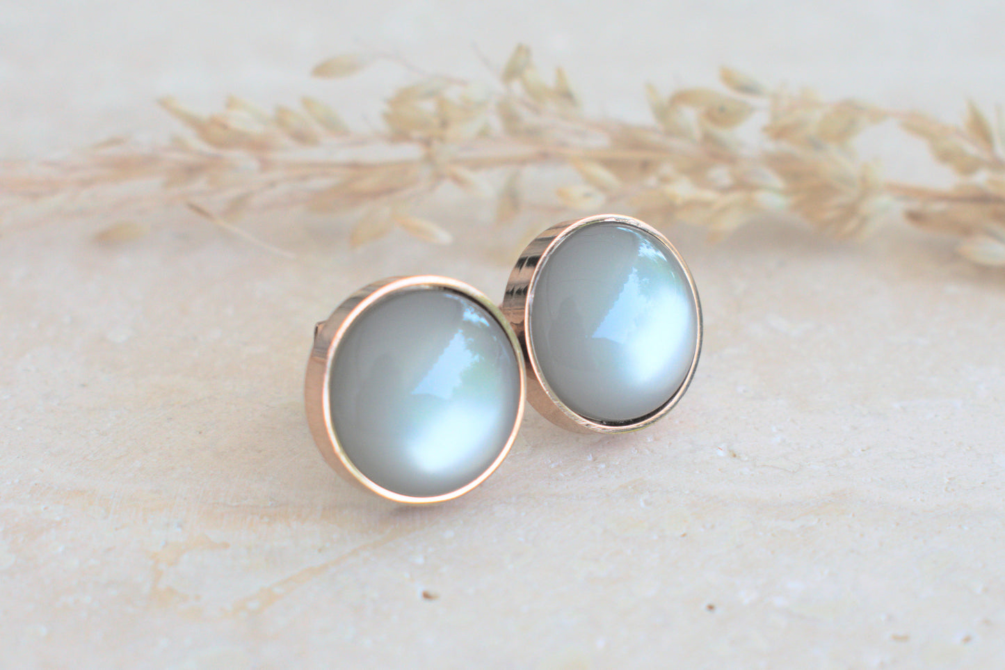 Rosegoldene Ohrstecker mit einem himmelblauen Cabochon