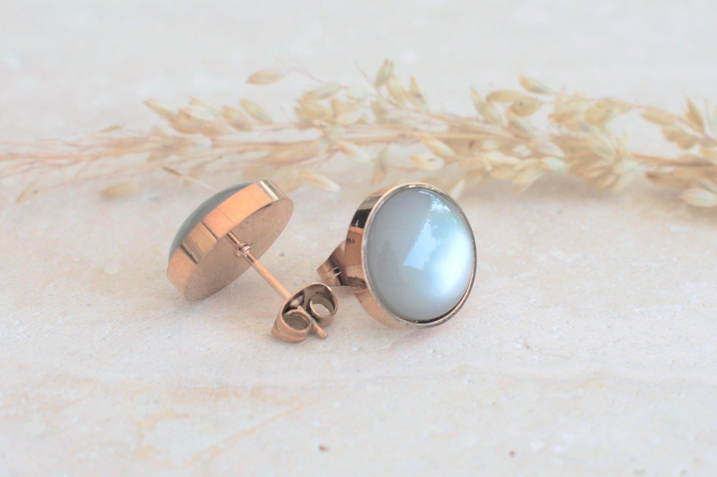 Rosegoldene Ohrstecker mit einem himmelblauen Cabochon