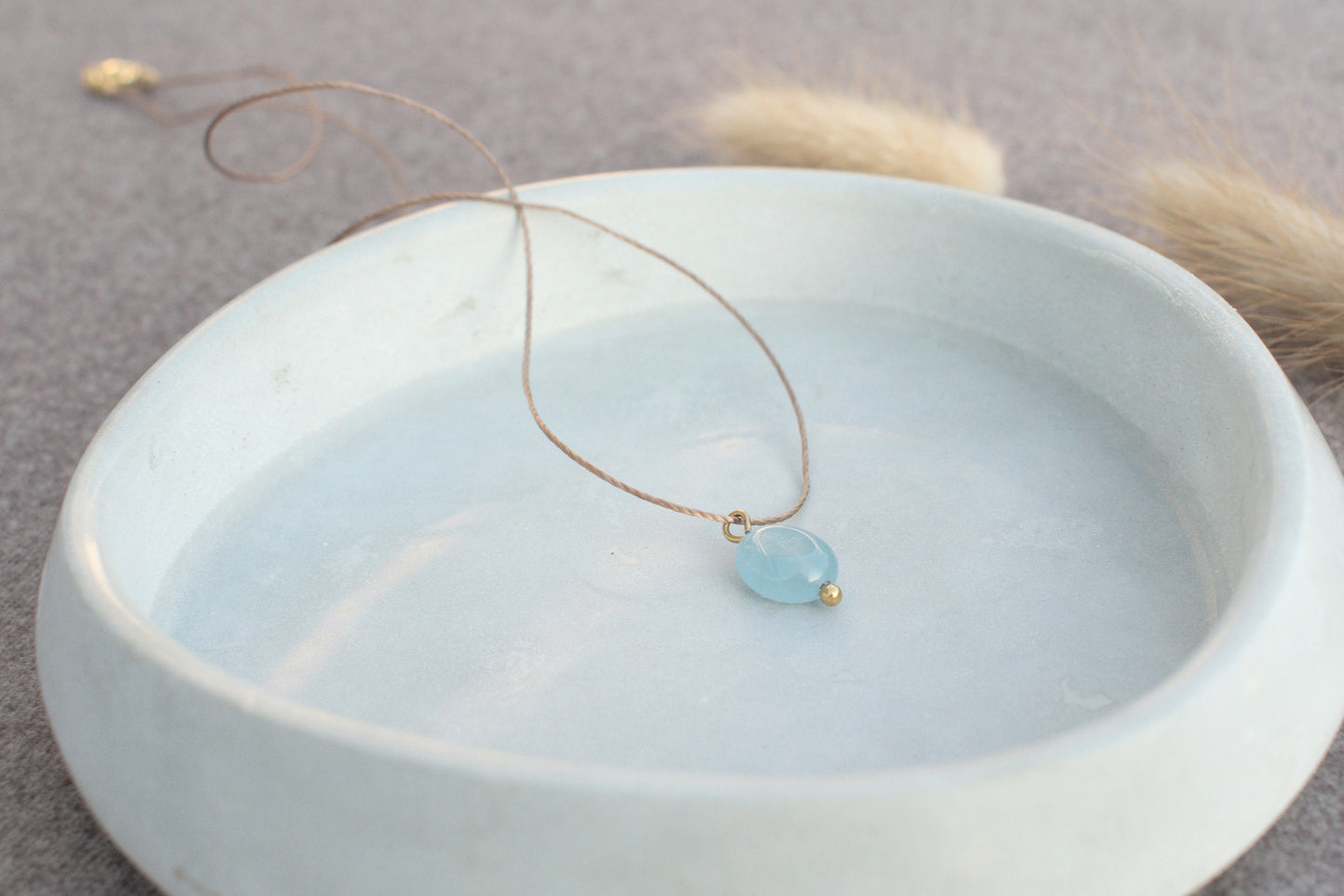 Minimalistische Halskette mit blauem, flachen Edelstein Aquamarin am braunen Nylonband