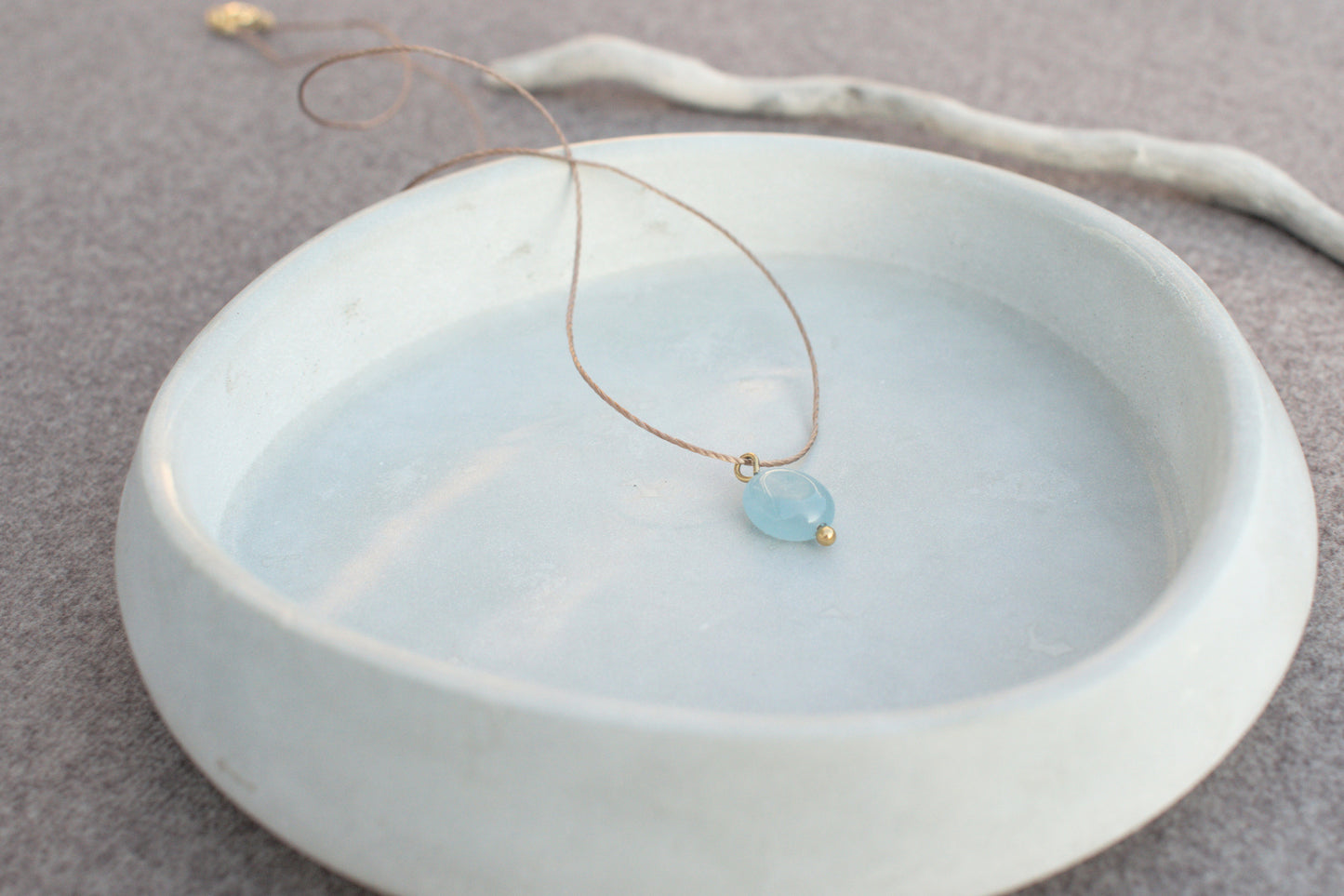 Minimalistische Halskette mit blauem, flachen Edelstein Aquamarin am braunen Nylonband