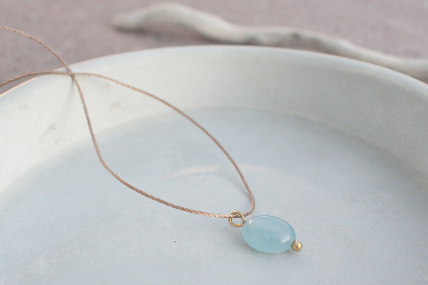 Minimalistische Halskette mit blauem, flachen Edelstein Aquamarin am braunen Nylonband