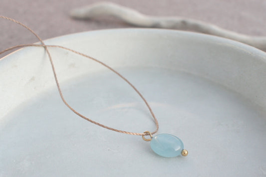 Minimalistische Halskette mit blauem, flachen Edelstein Aquamarin am braunen Nylonband
